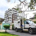 Weißer Mercedes Sprinter Camper vor einem modernen Gebäude.